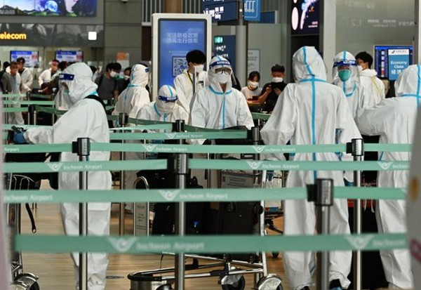 11일 인천국제공항 제1여객터미널 출국장에서 방역복을 착용한 외국인들이 탑승 수속을 밟고 있다.